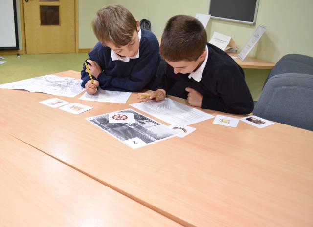 Students using a trade directory to find place names and their owners in Holt.